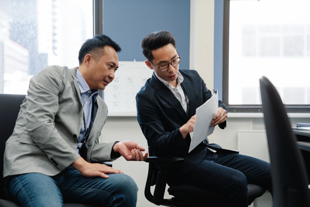 Two professionals engaged in a collaborative discussion in a modern office environment.